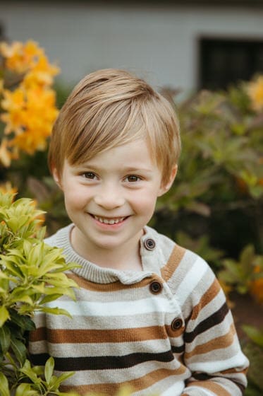 Boy smiling for the camera in a button up sweater