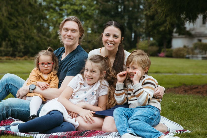 Family sitting in the grass in their spring outfits that coordinate but do not overly match