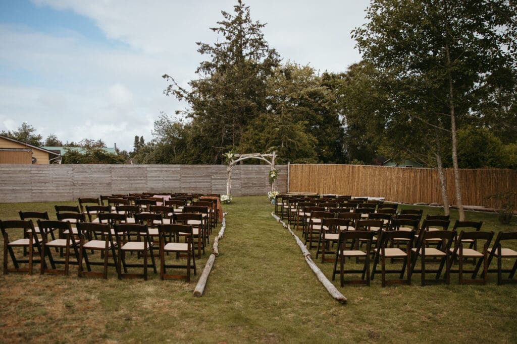 A ceremony set up with chairs and driftwood arch