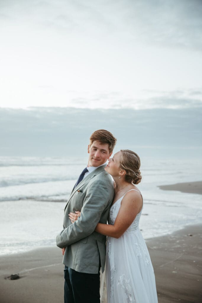 A couple looking at each other lovingly on the beach after their backyard wedding