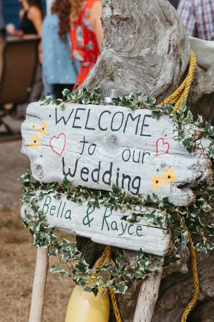 A wedding sign pained on pieces of driftwood